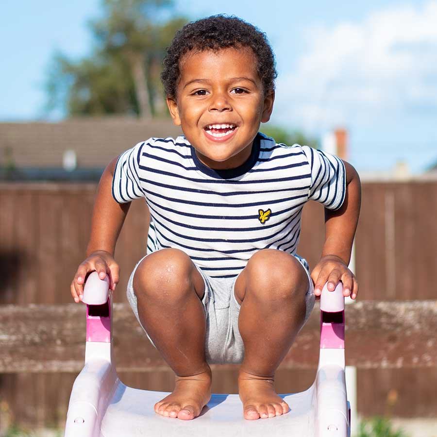 Children's portrait of a young boy on a slide