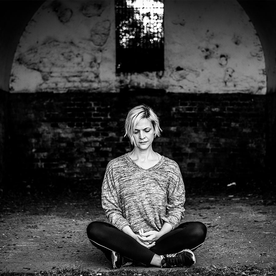 A woman meditating during her brand photography shoot at Wollaton Park